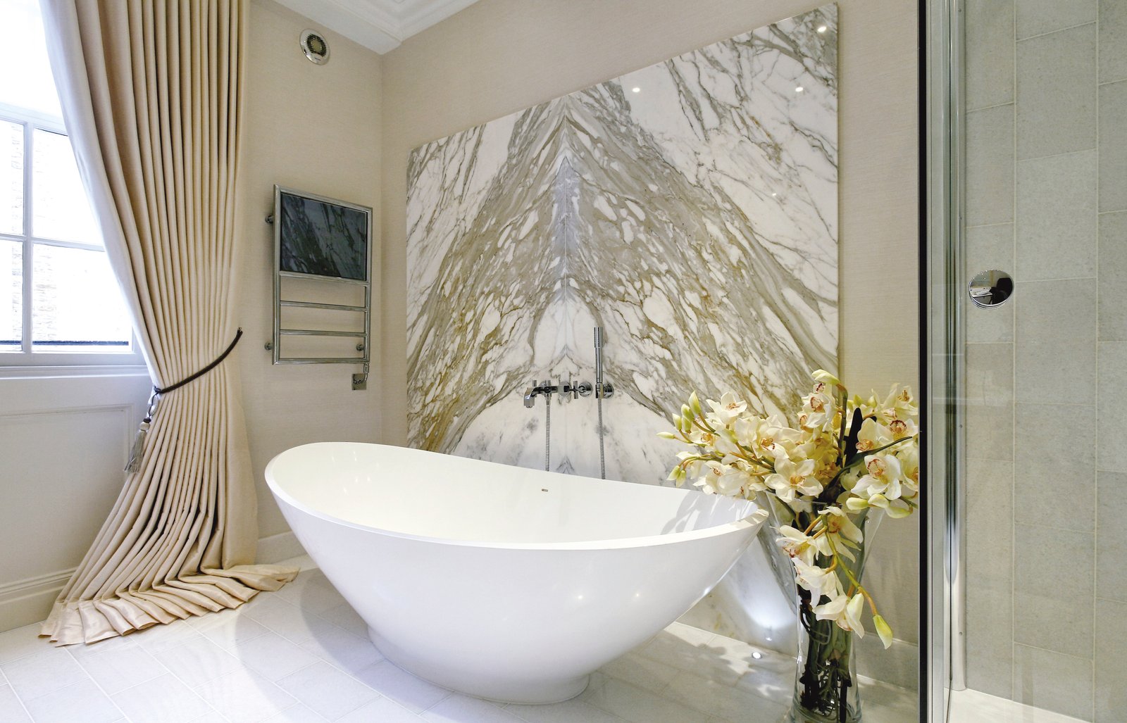 BC Designs BAB005 freestanding bath in a modern UK luxury bathroom - the bath has roughly 1100mm of foot-end clearance and full long-side access on both flanks, the minimum geometry that makes the freestanding piece read as sculptural rather than boxed-in