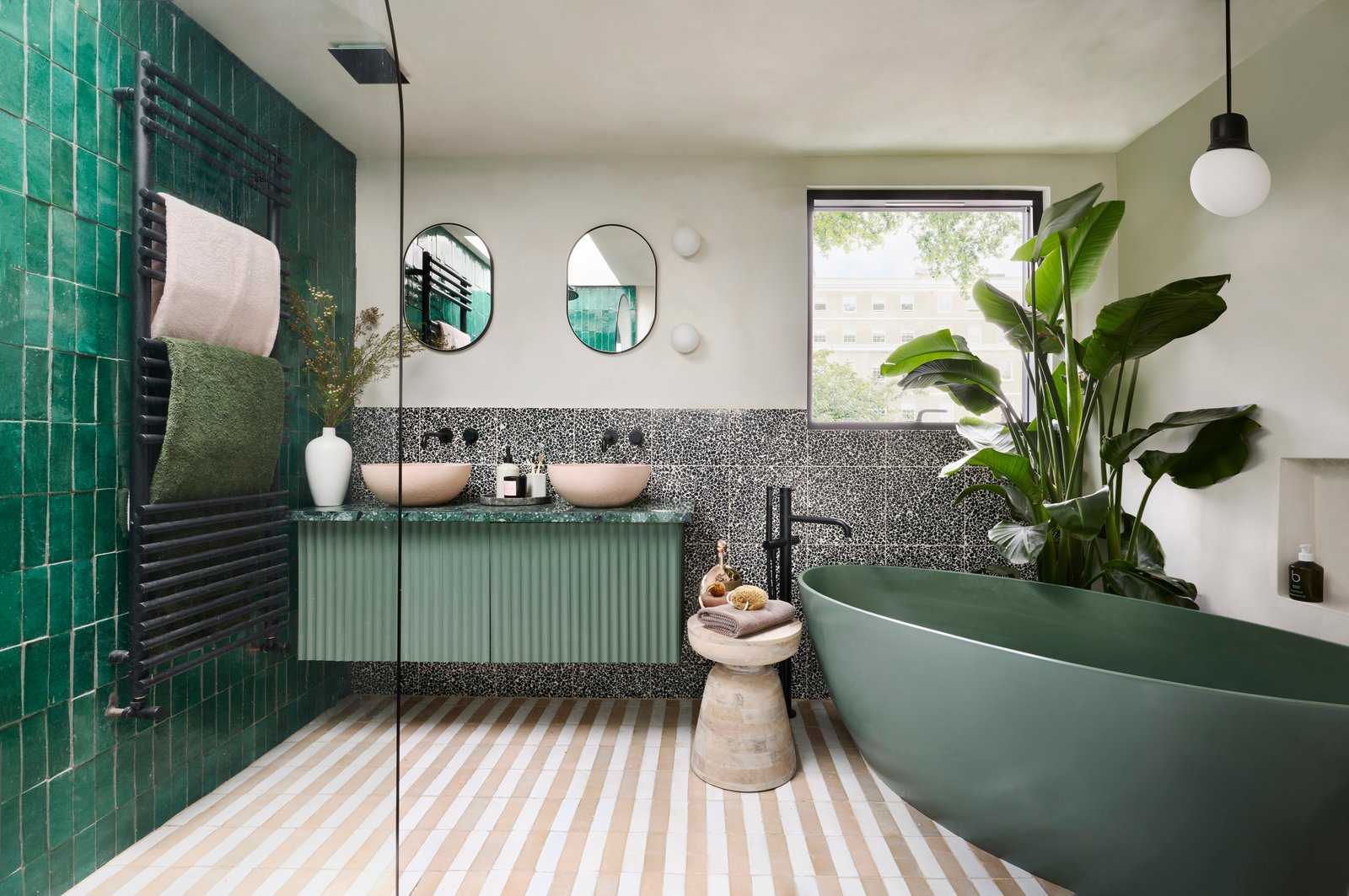 BC Designs freestanding bath in a deep-green panelled luxury bathroom - illustrating how tile, paint and panelling tones interact in real room light, the test that a showroom spotlight cannot replicate