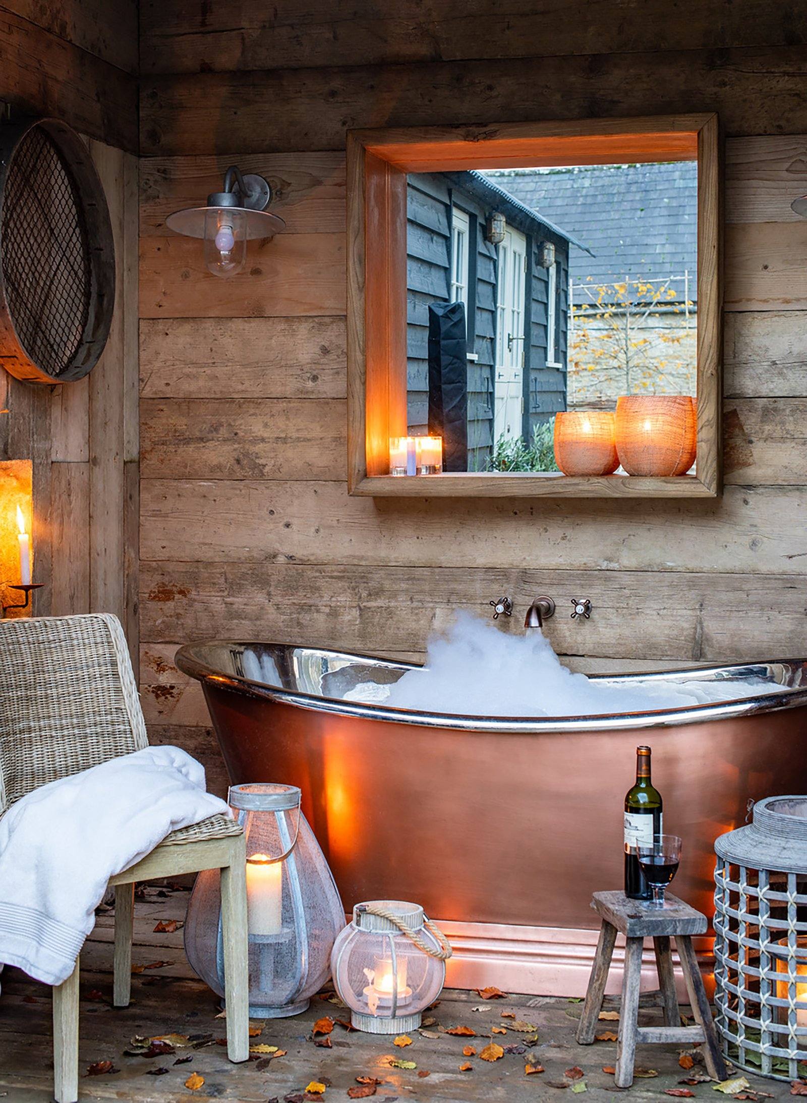 BC Designs BAC010 copper freestanding bath in a rustic barn bathroom - copper baths weigh 160-220kg dry and over 500kg full with bather, putting them firmly in the joist-reinforcement-always category for upstairs UK installations
