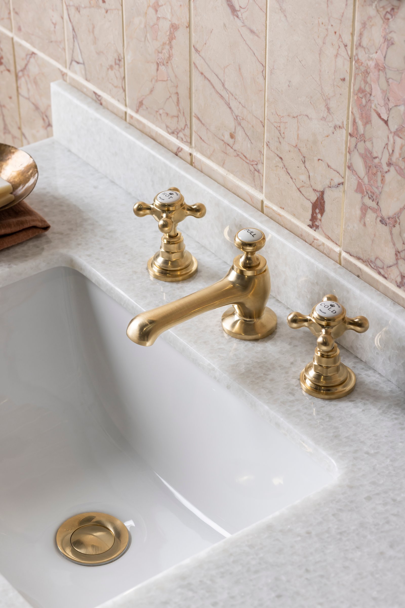 BC Designs three-hole brushed brass basin tap close-up - showing the finish family decision (brushed brass over chrome or matt black) that locks every other metal in the room at planning stage