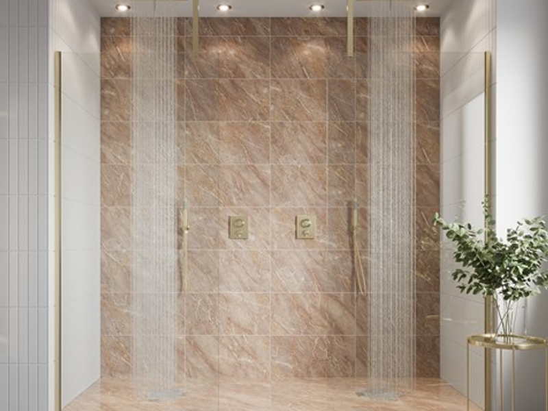 PVD bathroom brassware - Crosswater brushed brass PVD shower set with twin overhead heads and concealed thermostatic valves on a brown veined marble feature wall, the Physical Vapour Deposition coating that bonds the finish at a molecular level and outlasts electroplated equivalents by five-to-ten times in UK domestic use