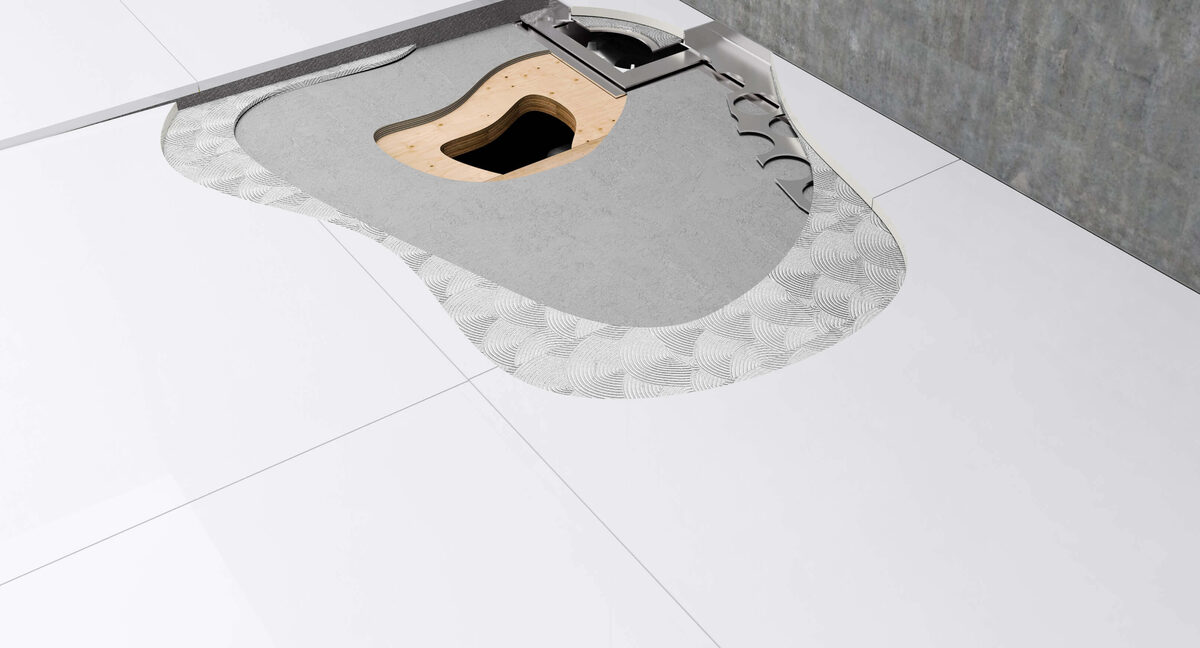 Cut-away of a wet-room floor former bedded in adhesive with the drain body and gully set into the floor build-up beneath the tile