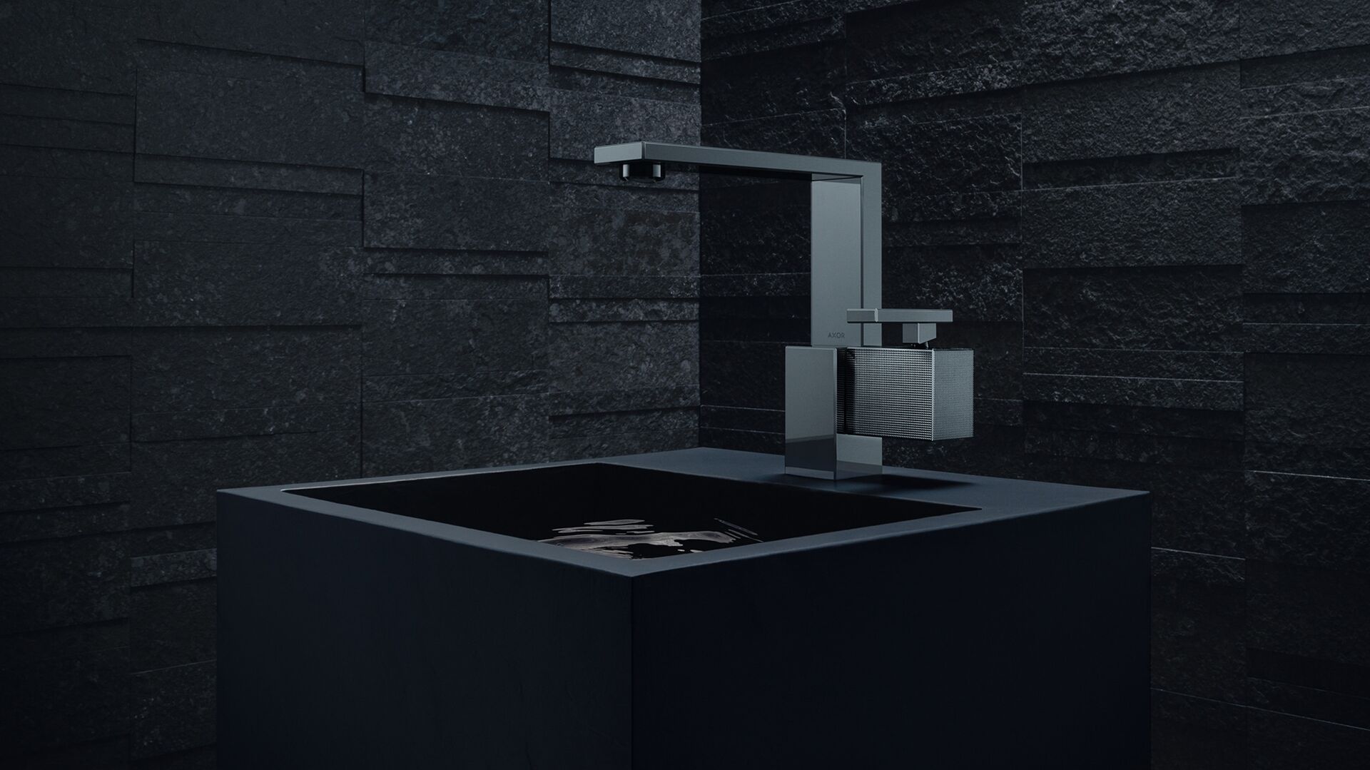 AXOR Edge basin mixer in Polished Black Chrome above a square black basin.