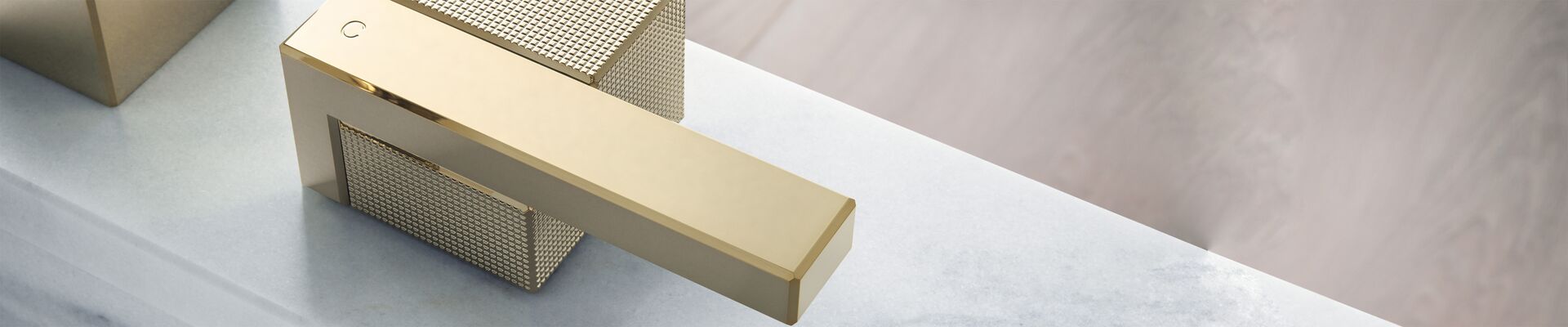 AXOR Edge bath mixer in Polished Gold Optic with precise prismatic surfaces
