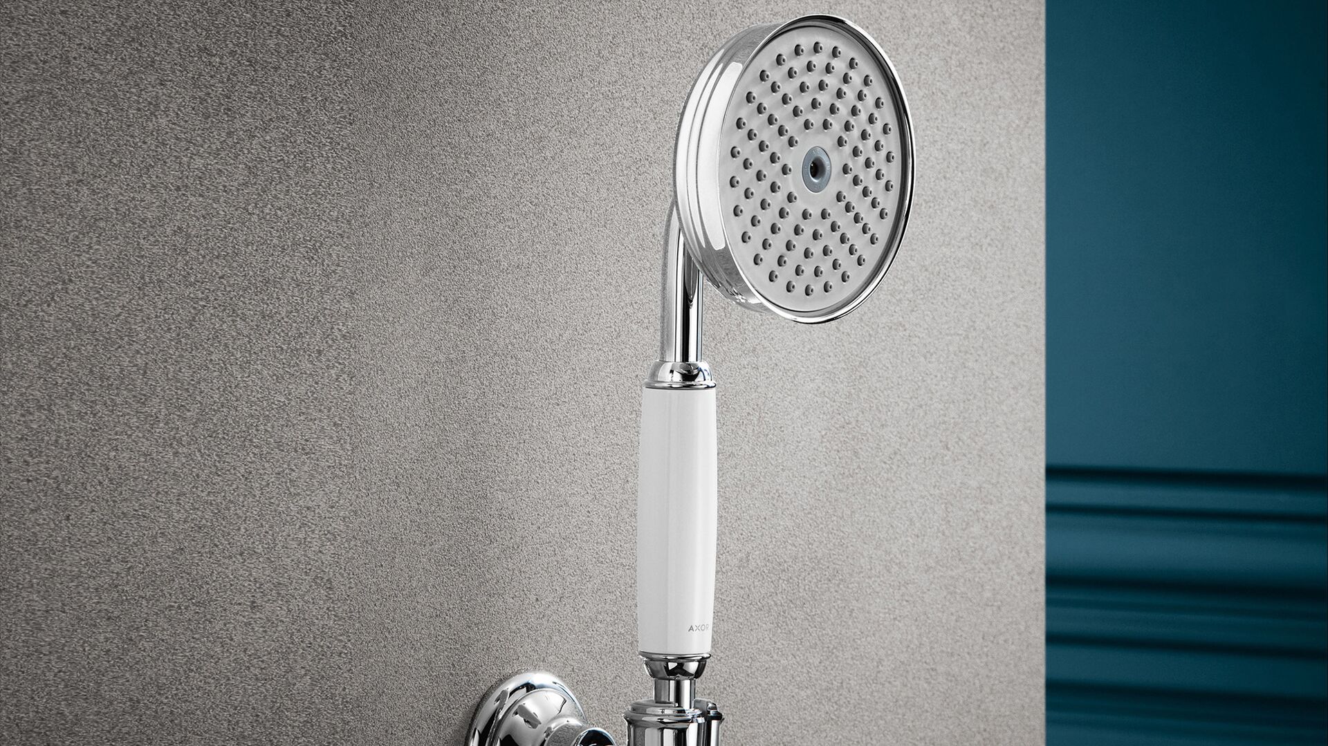 AXOR Montreux hand shower with a white porcelain handle against a textured wall and blue panelling.