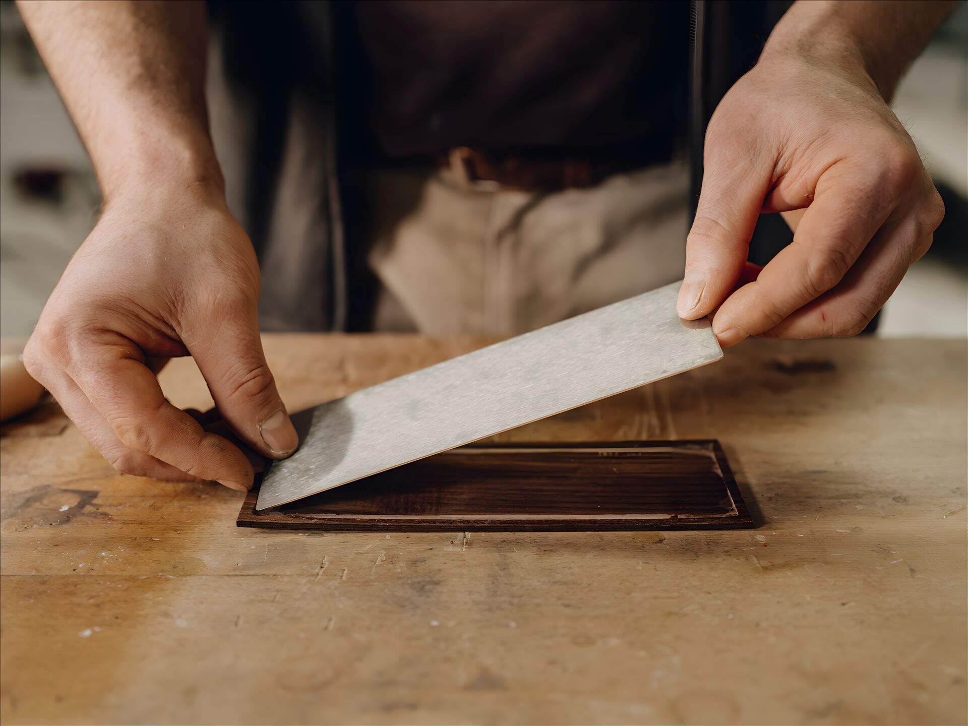 A craftsperson bonding an AXOR MyEdition walnut cover to its backing plate