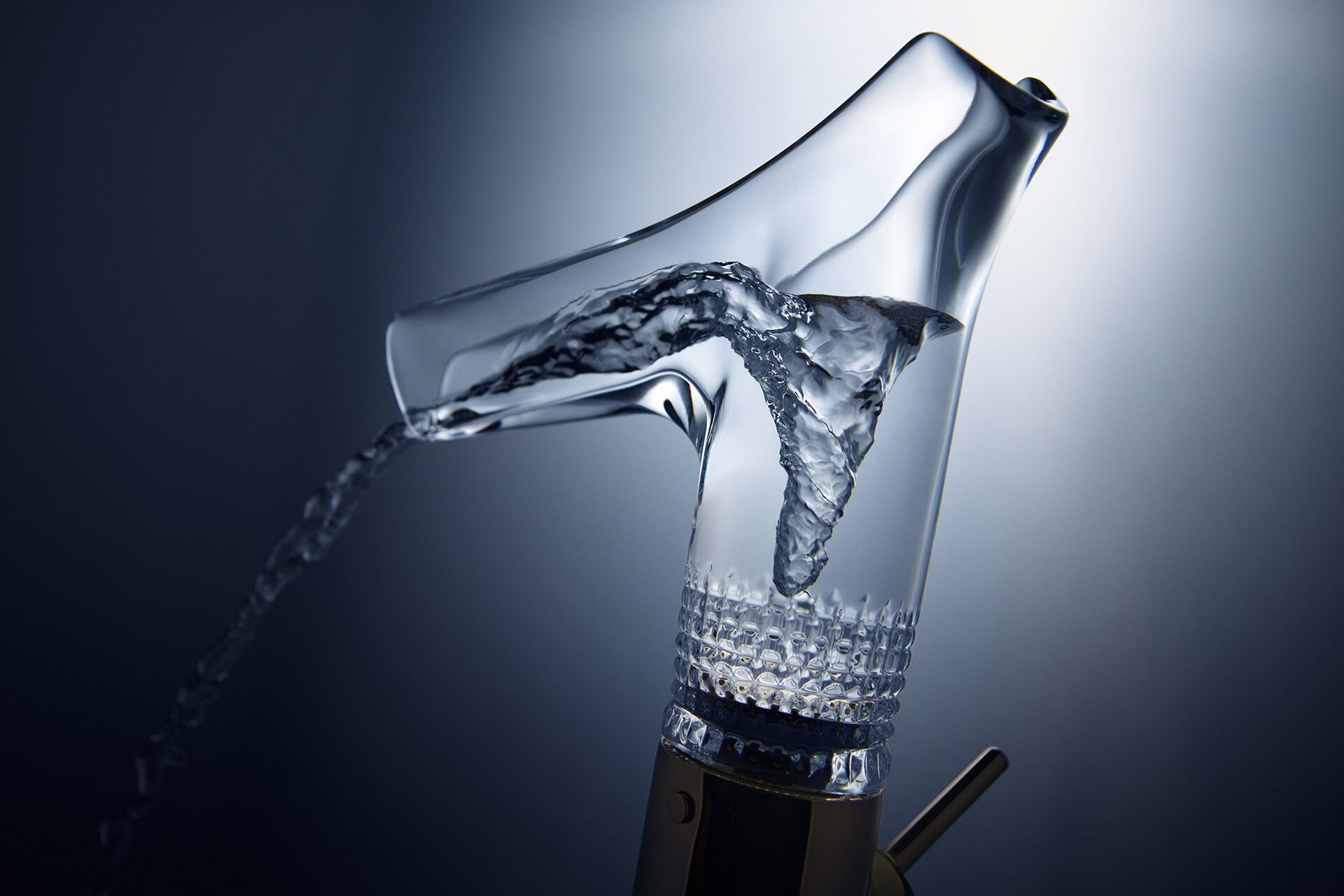 Close-up of the cut-glass base on an AXOR Starck V spout with water flowing