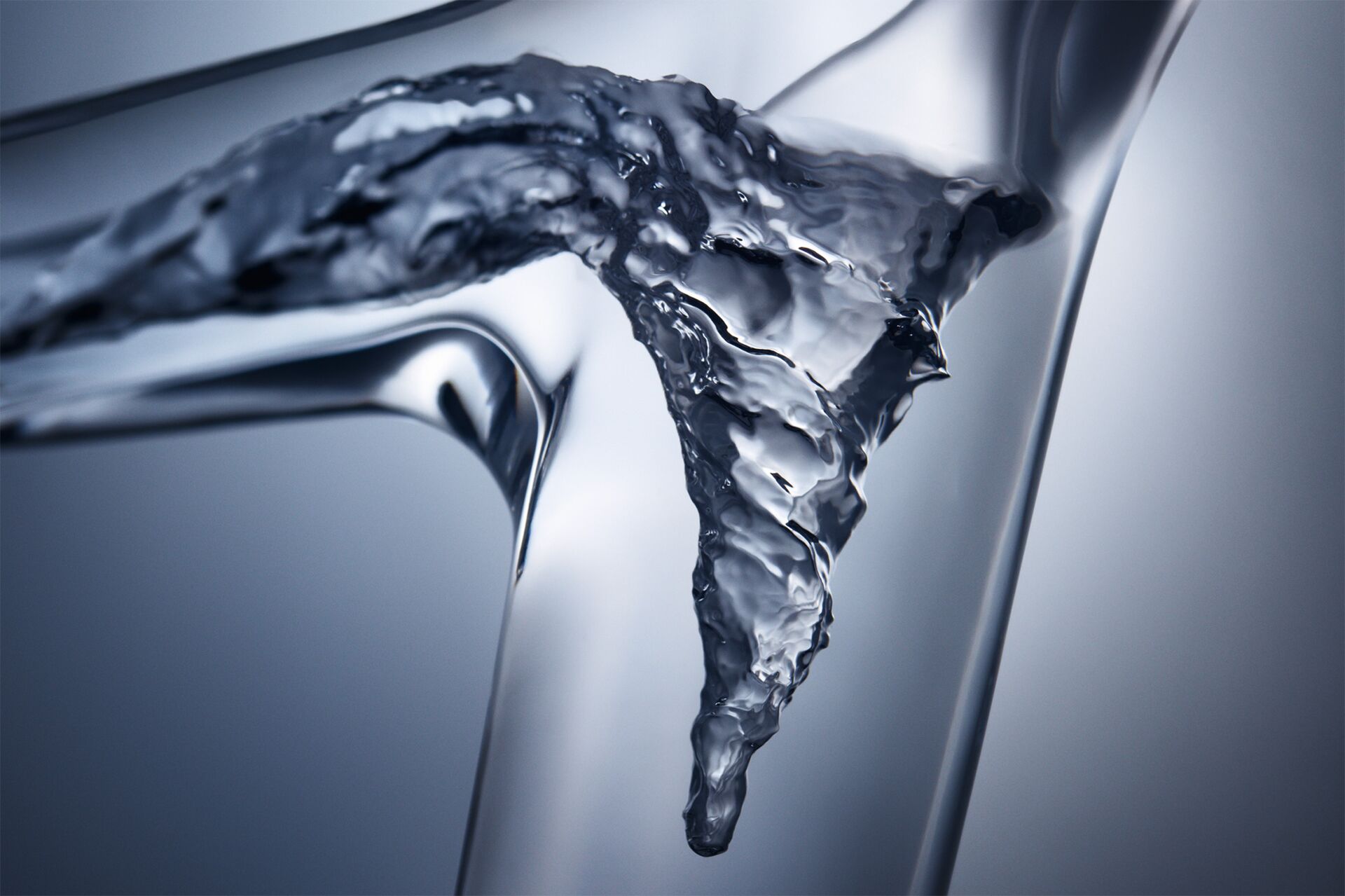 Water swirling inside the transparent curved spout of AXOR Starck V