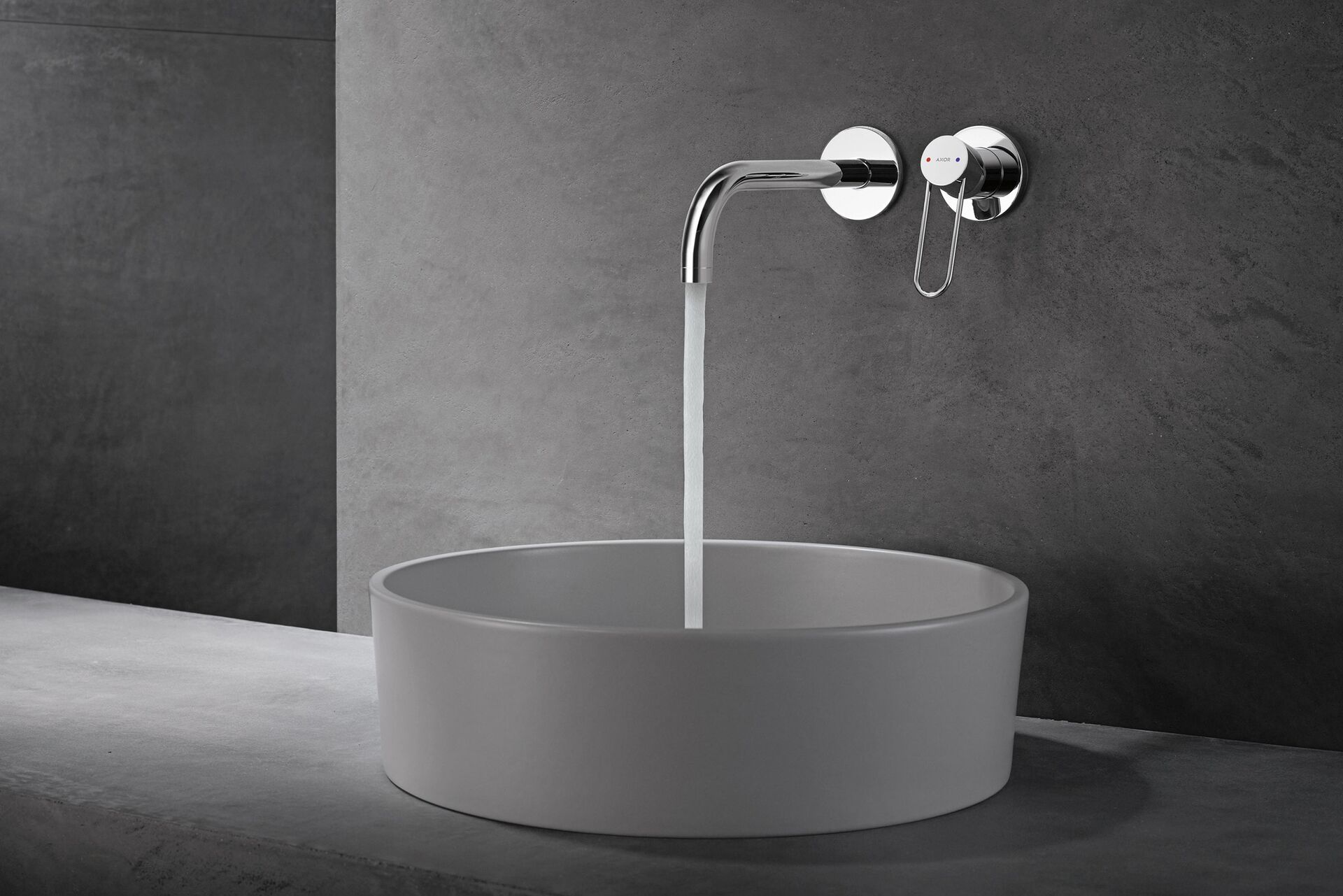 AXOR Uno wall-mounted curved spout and loop handle over a white bowl basin