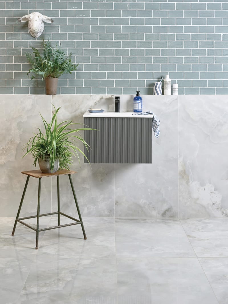 Light-toned large-format porcelain tiles in a compact UK bathroom with minimal grout lines