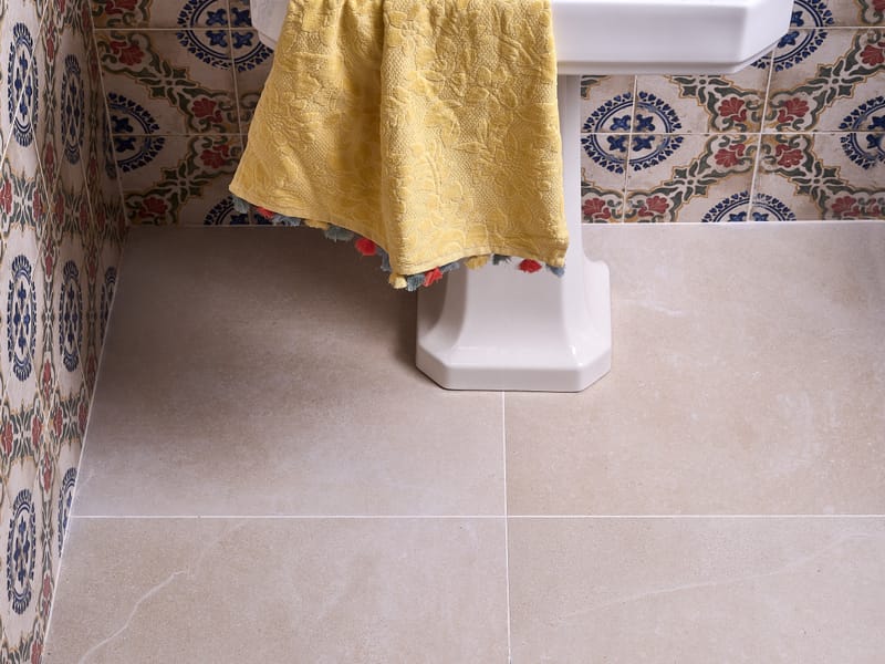 Large-format porcelain floor tiles creating a seamless surface in a small bathroom