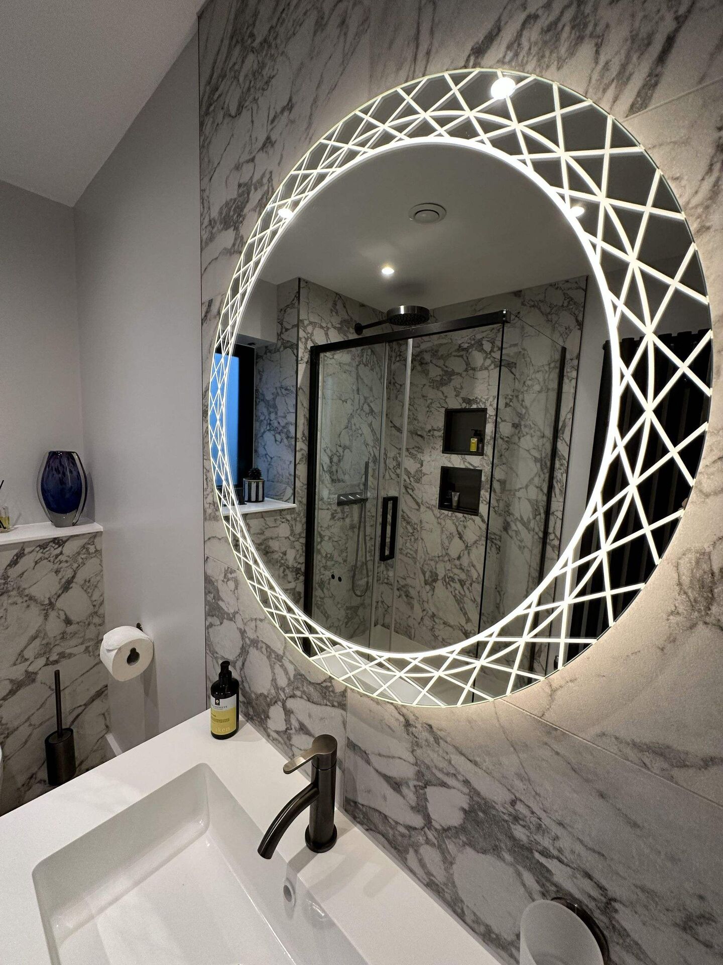 Backlit HiB Bellus geometric mirror glowing above the basin, Bures CO8 ensuite shower room