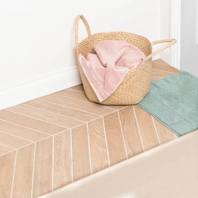 Chevron tile pattern with angled cuts forming a continuous V-shape on a utility room floor