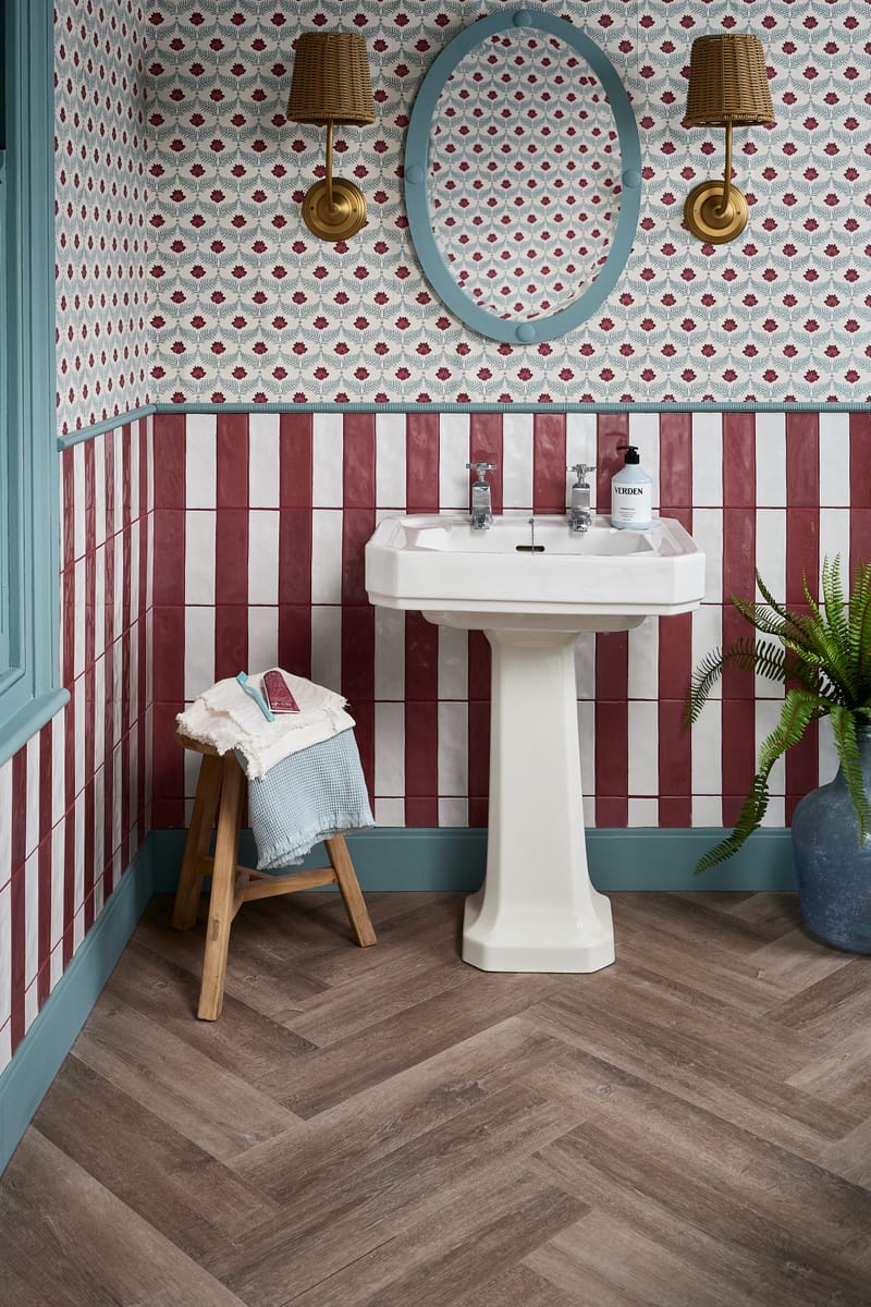 Herringbone floor tiles in an elegant bathroom with ornate wall moulding detail