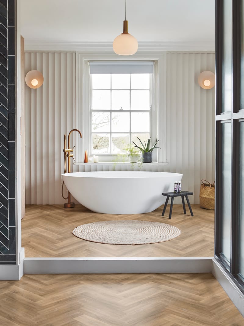 Luxury bathroom interior featuring herringbone floor tiles with ornate moulding detail
