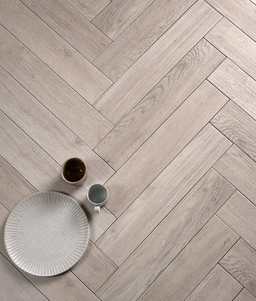 Finished herringbone wall tile installation with clean grout lines creating a striking bathroom feature wall