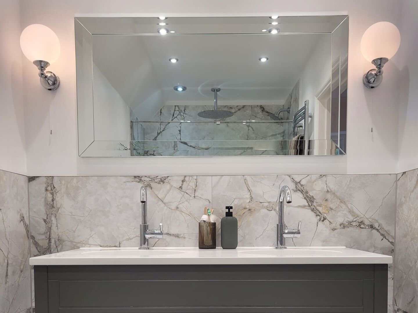 Grey Roper Rhodes double vanity with twin chrome mixer taps under a bevelled mirror, flanked by two globe wall lights, Tiptree master ensuite