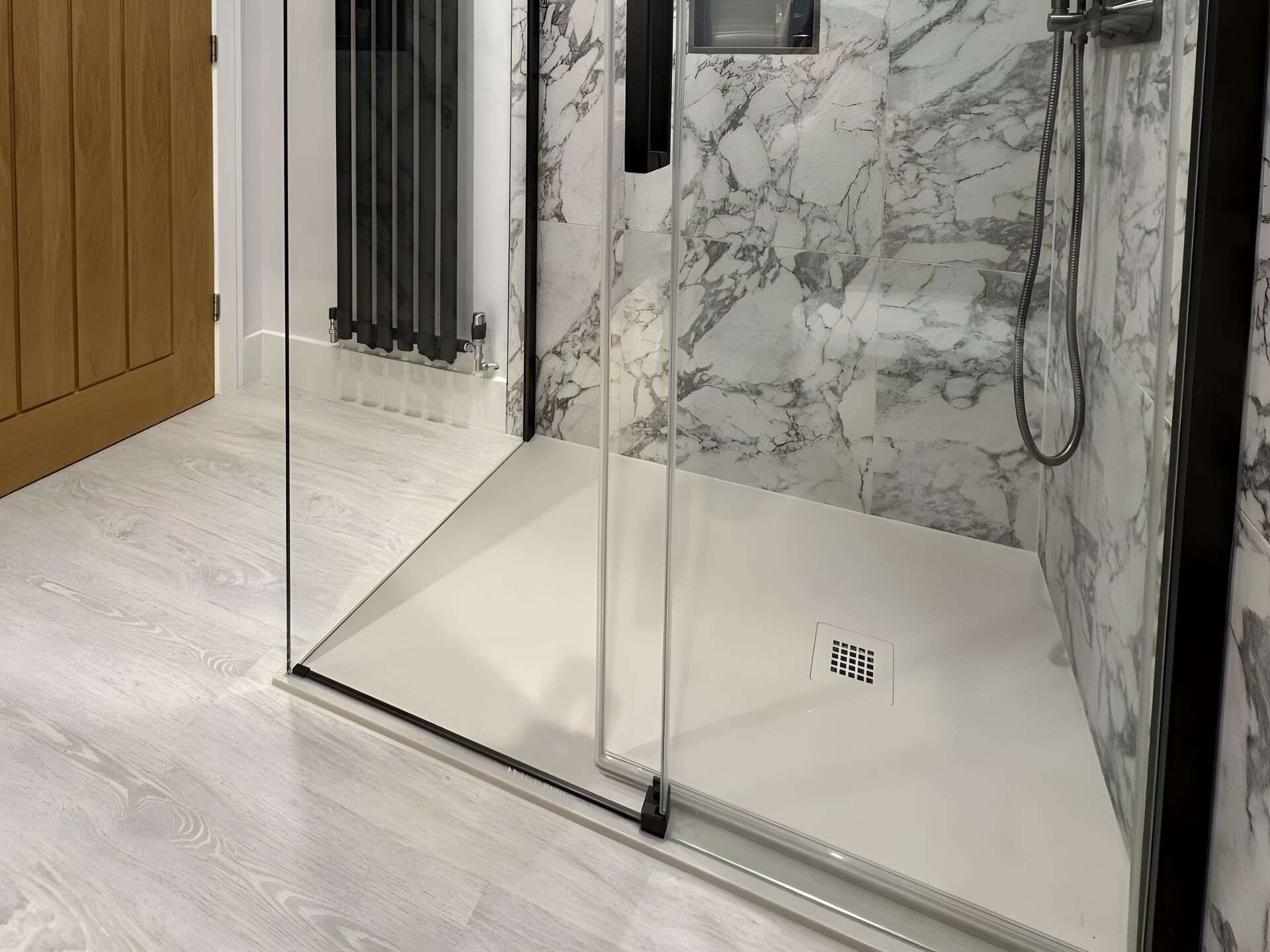 Low-profile Tissino Giorgio Lux shower tray under a black-framed glass door, Bures CO8 ensuite shower room