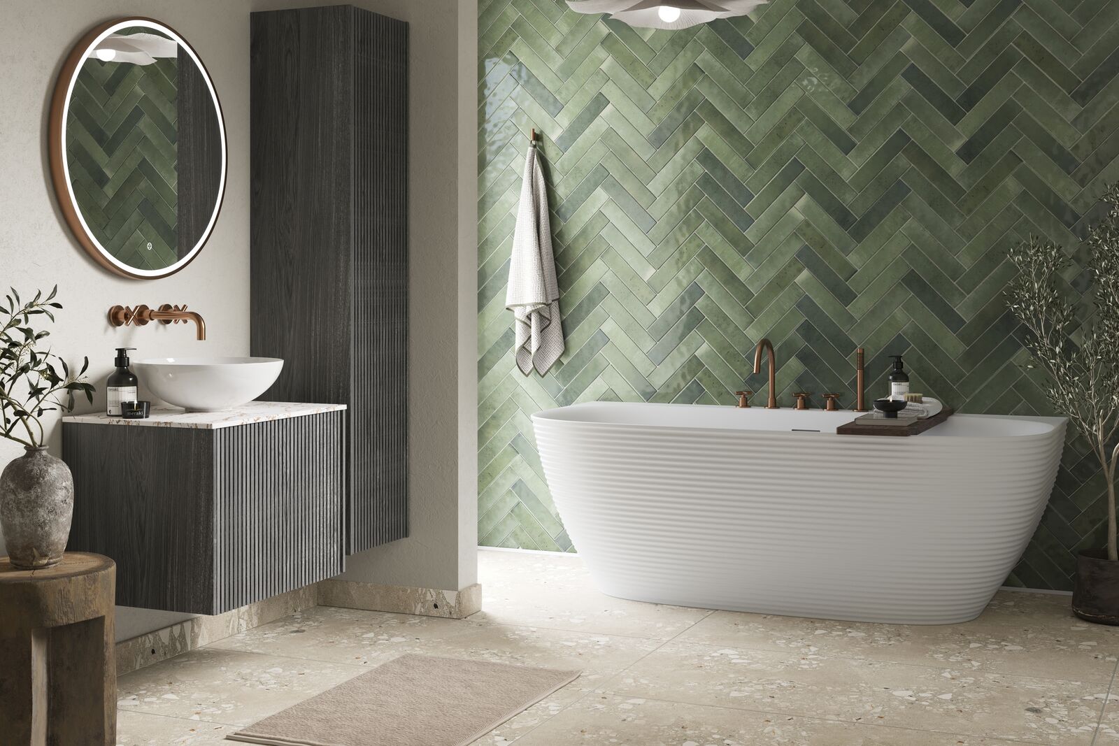 Sage-green herringbone tile bathroom with rose-gold brassware and a terrazzo floor