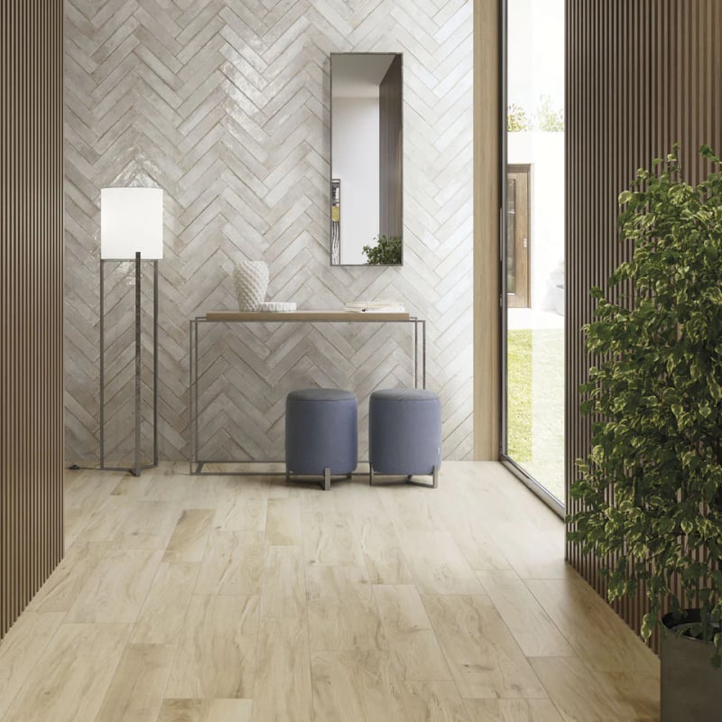 Herringbone tile layout on bathroom wall with oyster-toned rectangular tiles creating zig-zag pattern