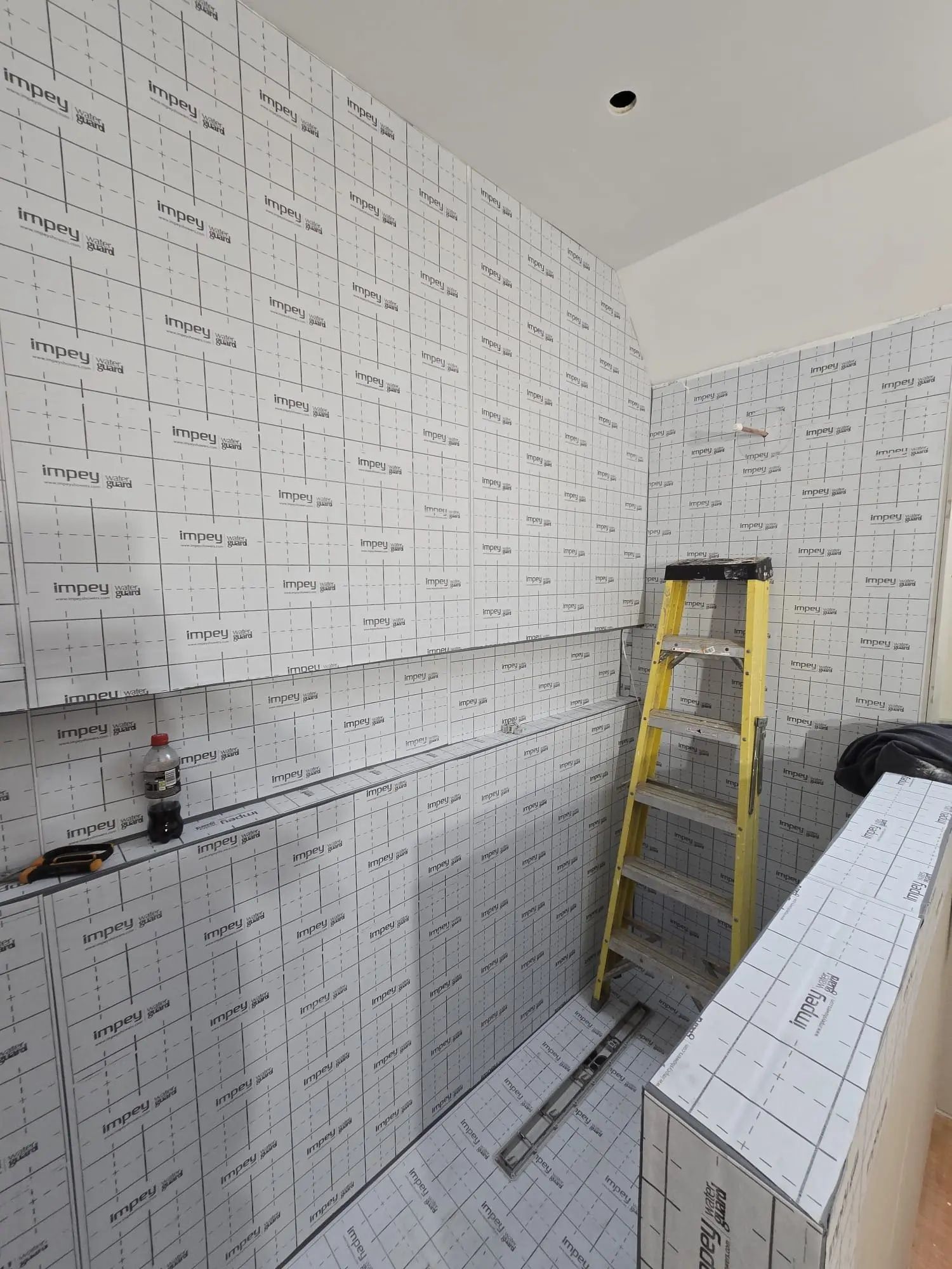 Professional wetroom waterproofing membrane installation showing complete bathroom tanking before tiling