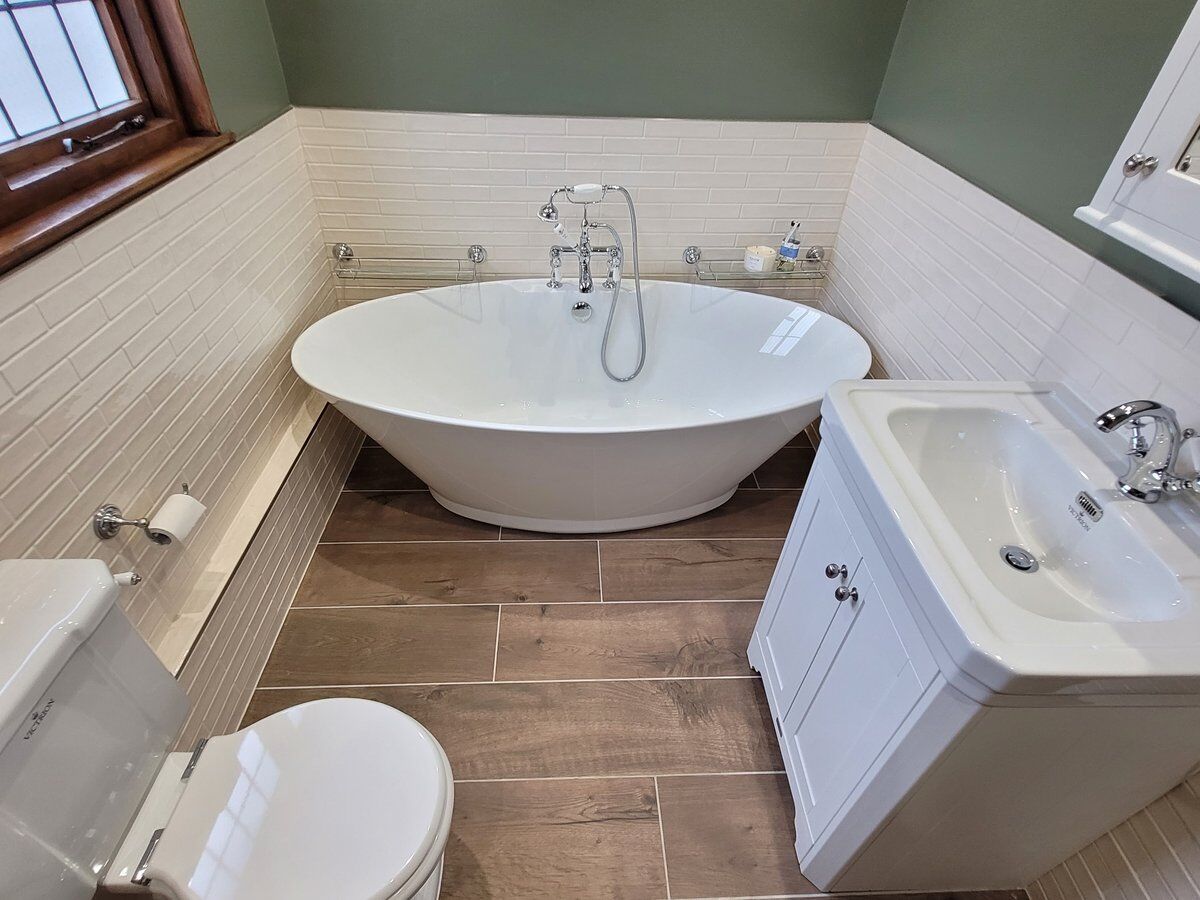 Freestanding bath, traditional WC and vanity unit on the same continuous wood-effect wetroom floor tile, Great Bardfield CM6 family wetroom