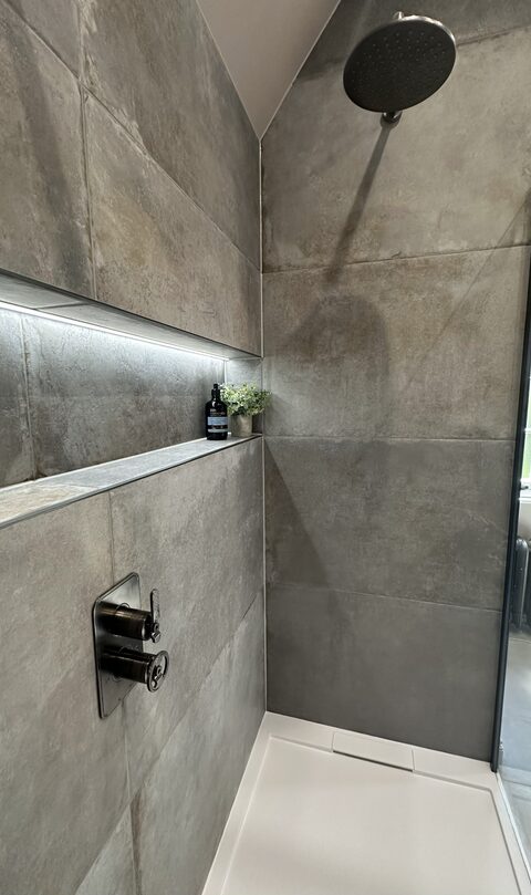Luxury wetroom renovation by Bowman Bathrooms — large-format tiles, LED niche lighting, black rainfall shower