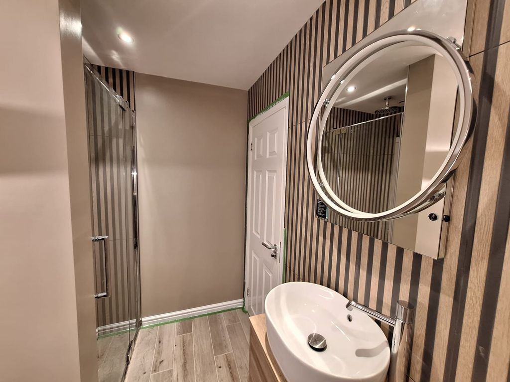 View from entrance showing shower glass, door, LED mirror and basin on slat wall — Benfleet SS7 master ensuite