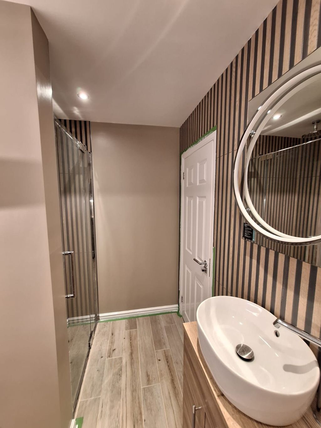 Compact Benfleet SS7 ensuite with a Crosswater shower door, countertop basin and HiB Solas mirror on a slatted wall