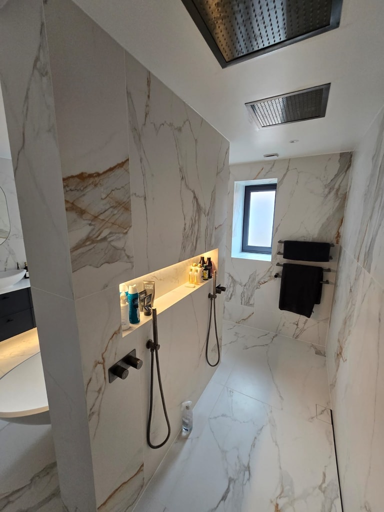 Dual shower handsets with brushed black brassware and lit niche in Billericay CM11 master ensuite
