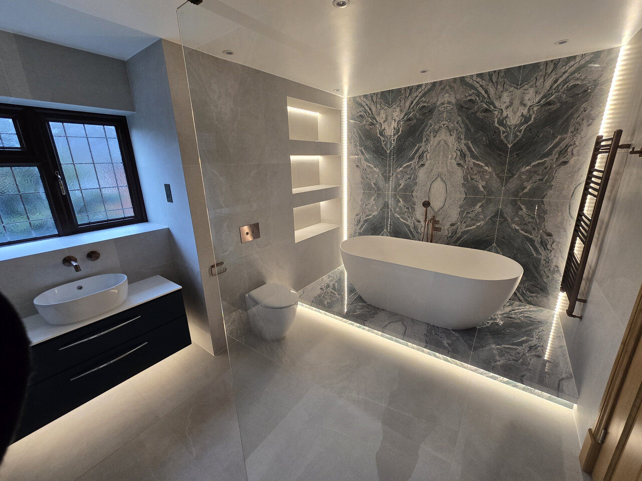 Luxury family bathroom with bookmatched blue tiles in Bradwell CM77