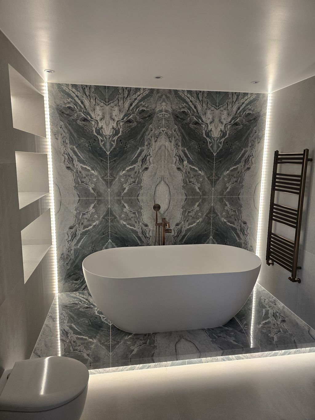 Ca' Pietra Ocean Magnifique bookmatched tiles behind freestanding bath — Bradwell CM77