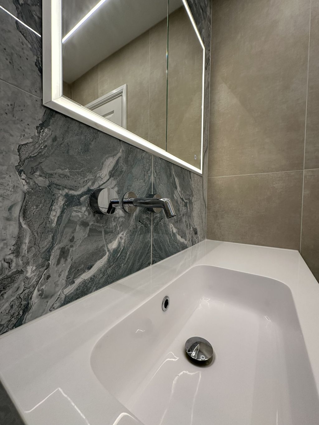 Wall-mounted JTP chrome basin tap close-up above Calypso Loreto vanity with HiB Vanquish mirror in Braintree CM7 ensuite