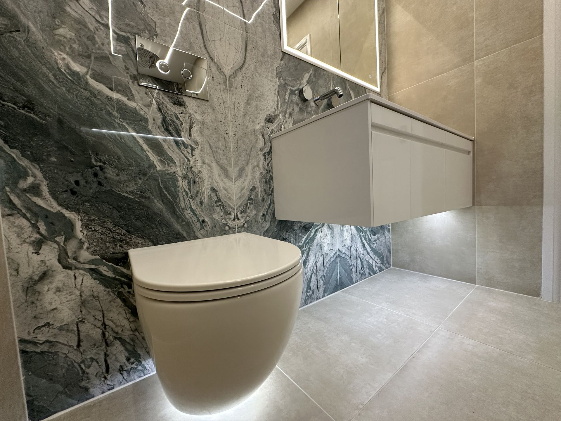Wall-hung WC with chrome flush plate, under-vanity LED strip, and Ca' Pietra Loft Pearl wall tiles in Braintree CM7 ensuite