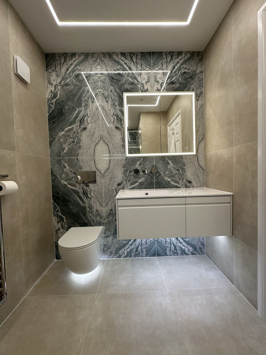 Ca' Pietra Ocean Magnifique bookmatched feature wall with Calypso Loreto vanity and wall-hung WC in Braintree CM7 ensuite wetroom