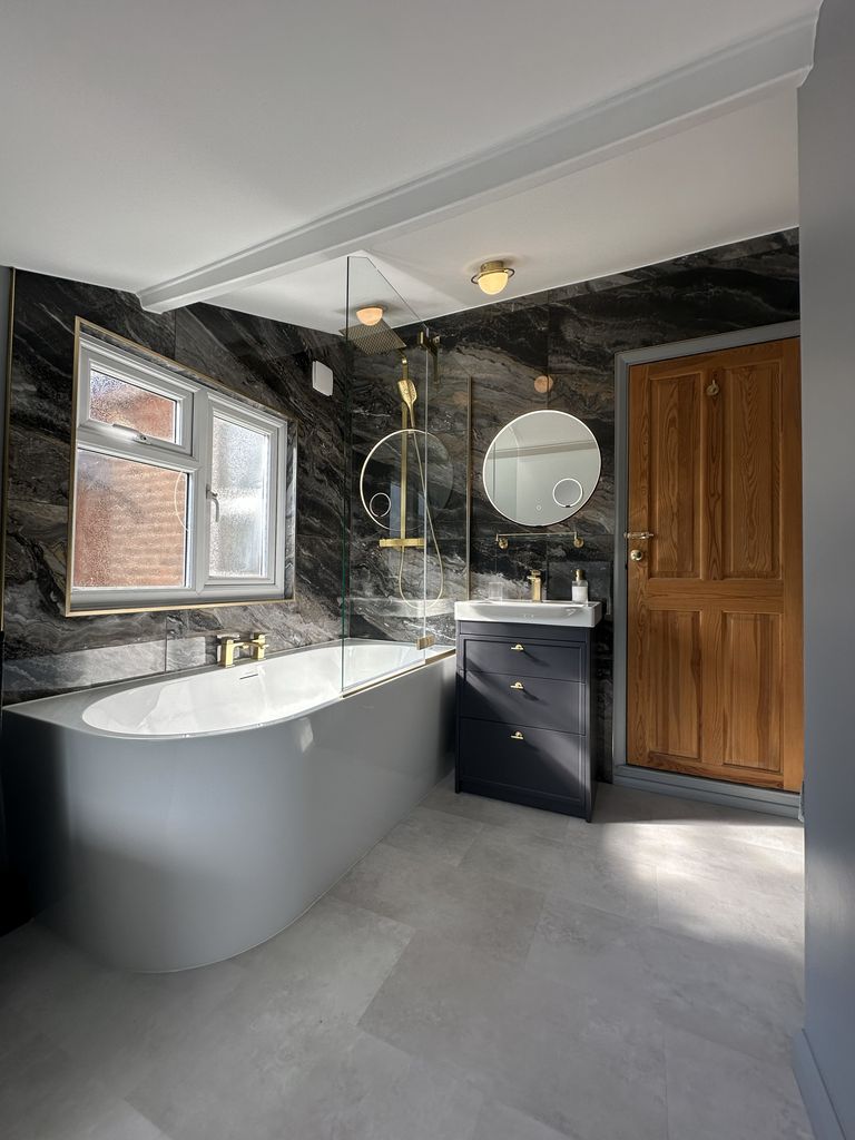 J-shape bath and Roper Rhodes Concierge vanity with Ca' Pietra Nero Magnifique bookmatched marble feature wall in Braintree CM7 family bathroom