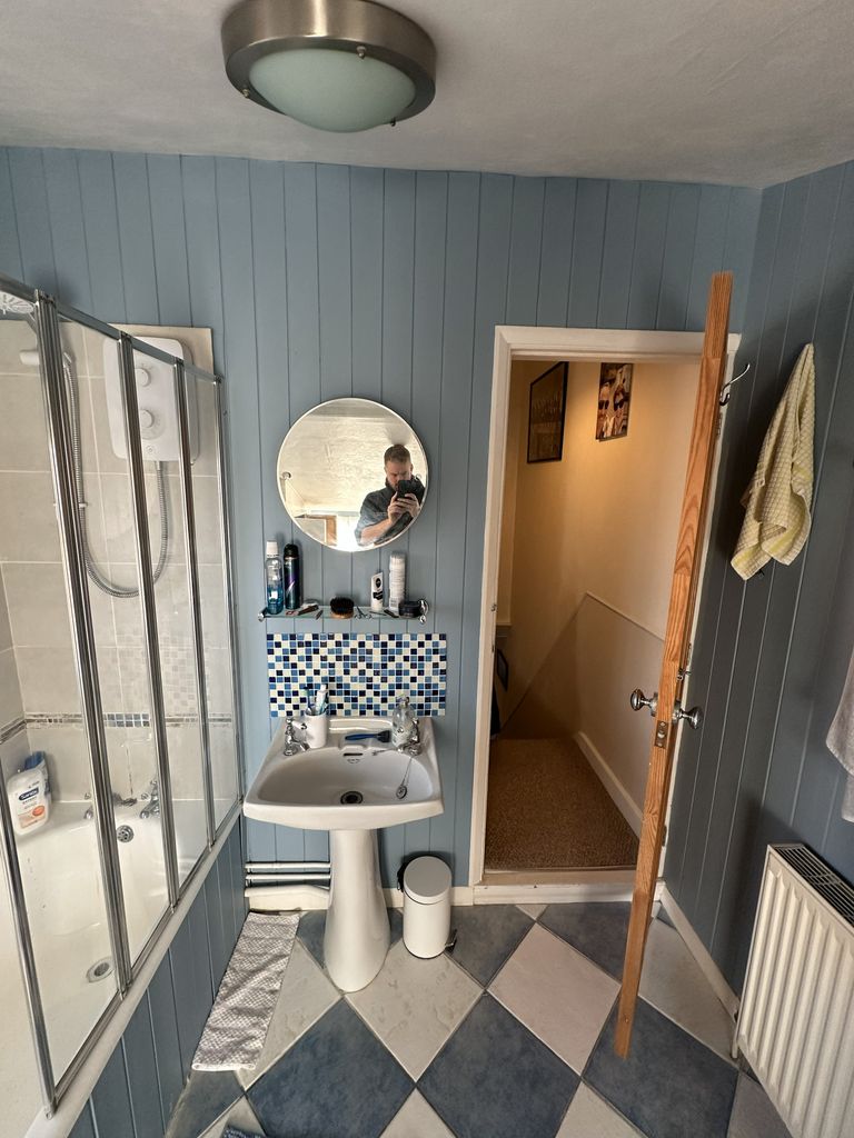 Original family bathroom Braintree CM7 before renovation showing pedestal basin with mosaic tiles and bath screen