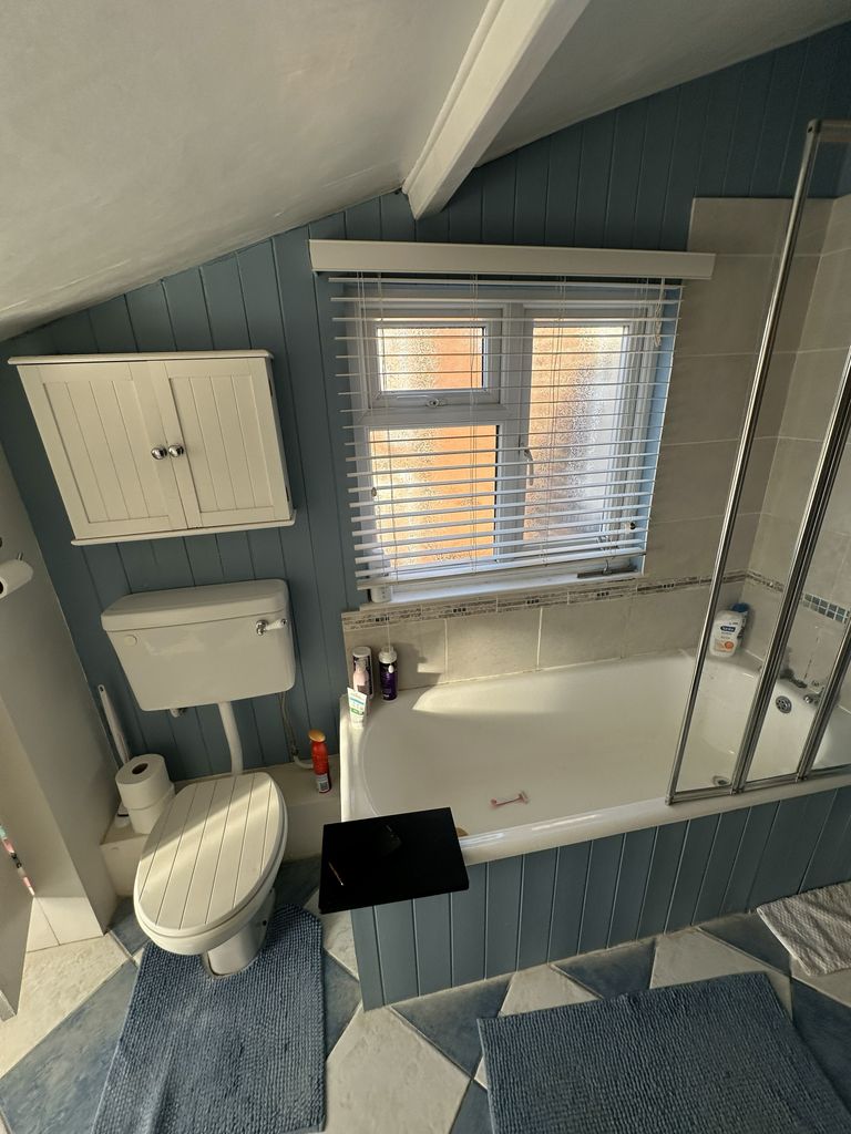 Original family bathroom Braintree CM7 before renovation showing toilet beside bath and window