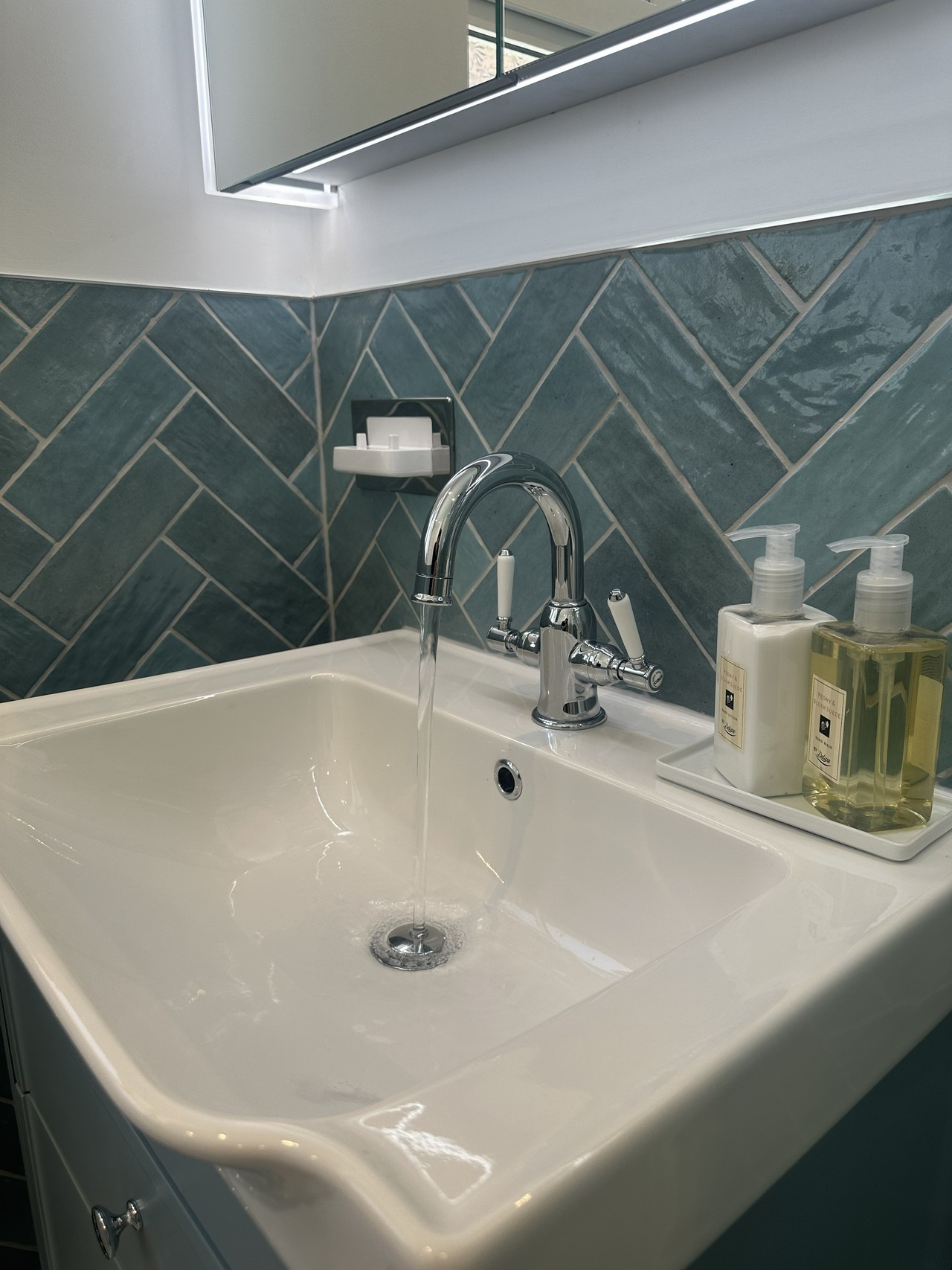 Keswick chrome basin mixer with water running on Academy basin with herringbone tiles in Brentwood CM13 bathroom