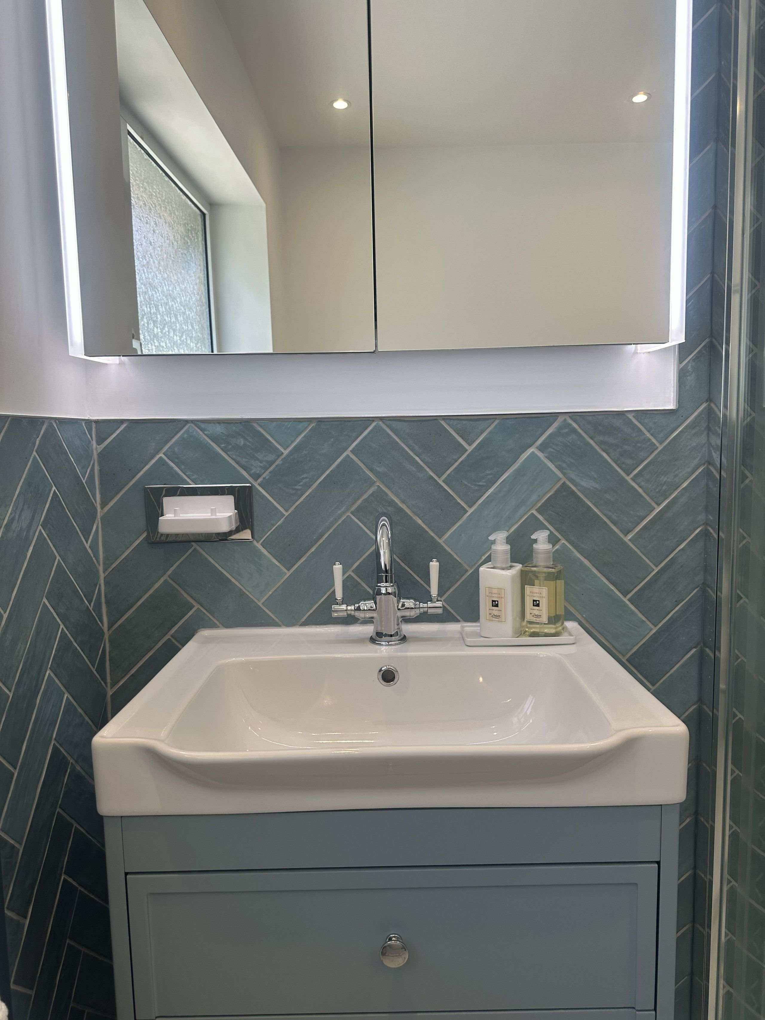 Herringbone tiled shower feature wall in Brentwood CM13 family bathroom installation by Bowmans