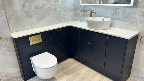 Navy blue Be Modern Atlanta fitted furniture with white worktop and countertop basin in a Brentwood luxury bathroom