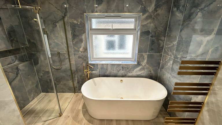 Crosswater wetroom glass beside a BC Designs Viado freestanding bath under the window in a completed Brentwood CM13 bathroom
