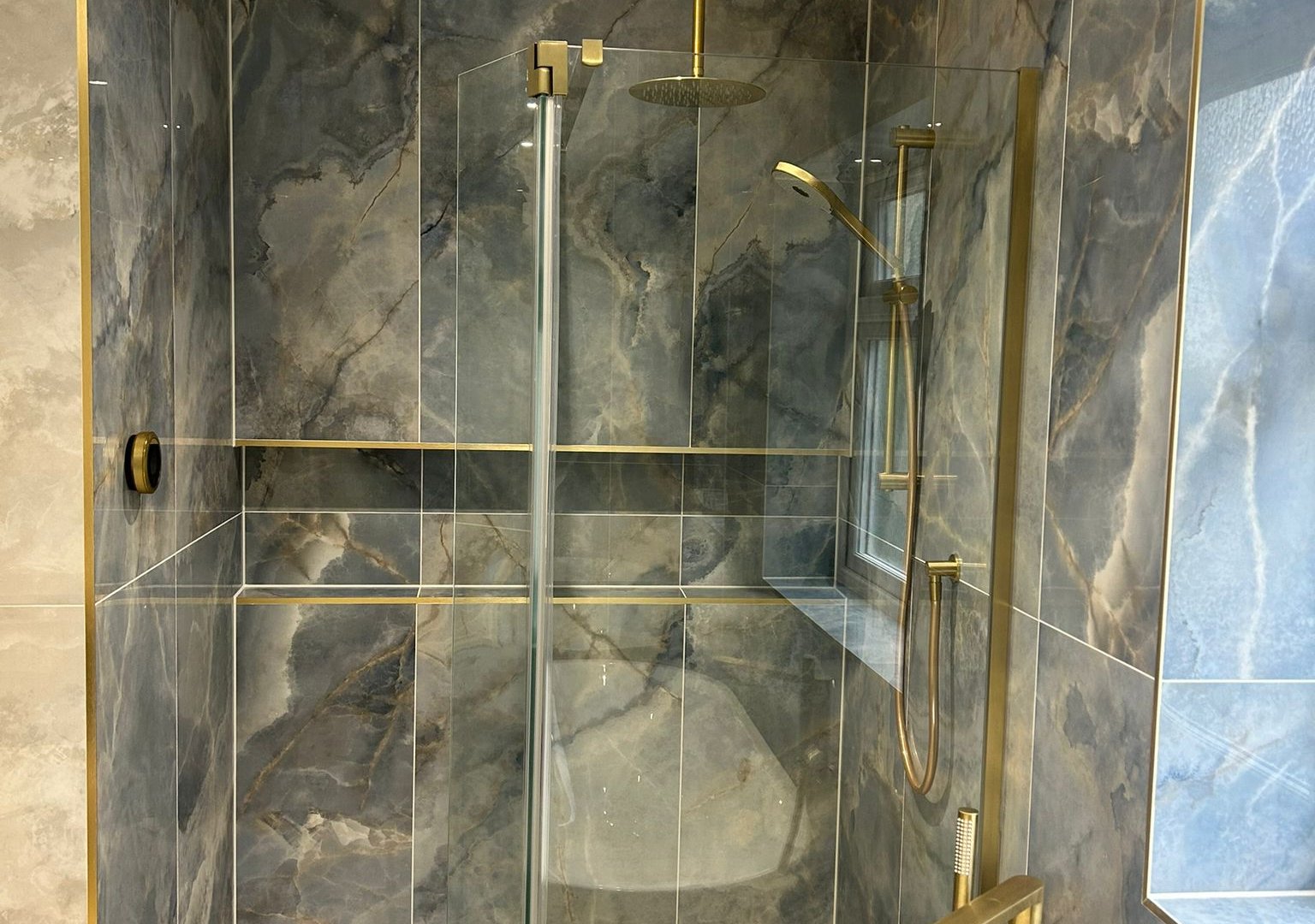 Wetroom shower with blue onyx Ca' Pietra tiles and Elisa Intuition shower kit in brushed brass Brentwood CM13