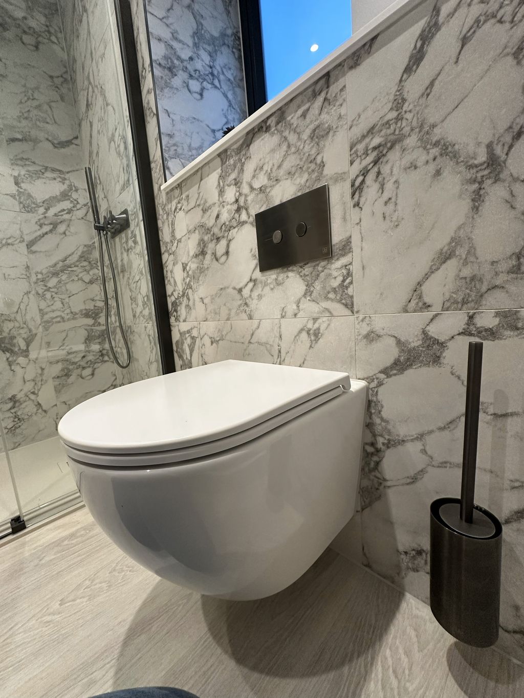 Wall-hung WC with brushed black flush plate and toilet brush holder in Bures CO8 ensuite