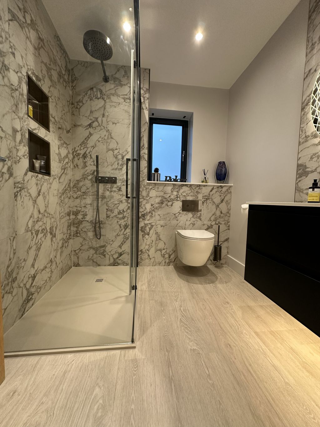 Full ensuite overview with Ca' Pietra tiles shower enclosure wall-hung WC and vanity in Bures CO8