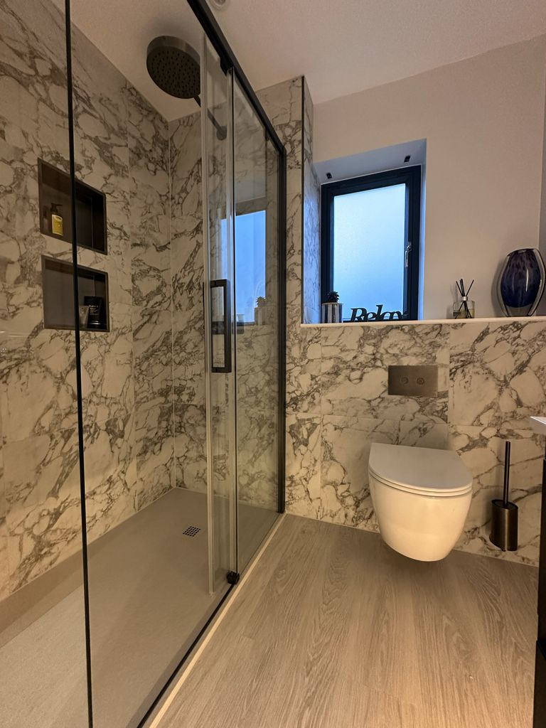 Walk-in shower with JTP KONO brushed black fittings and Ca' Pietra tiles in Bures CO8 ensuite