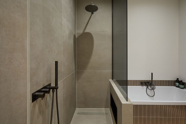 Matt black rain shower over level-access tiled floor beside bath Chelmsford CM2 Essex