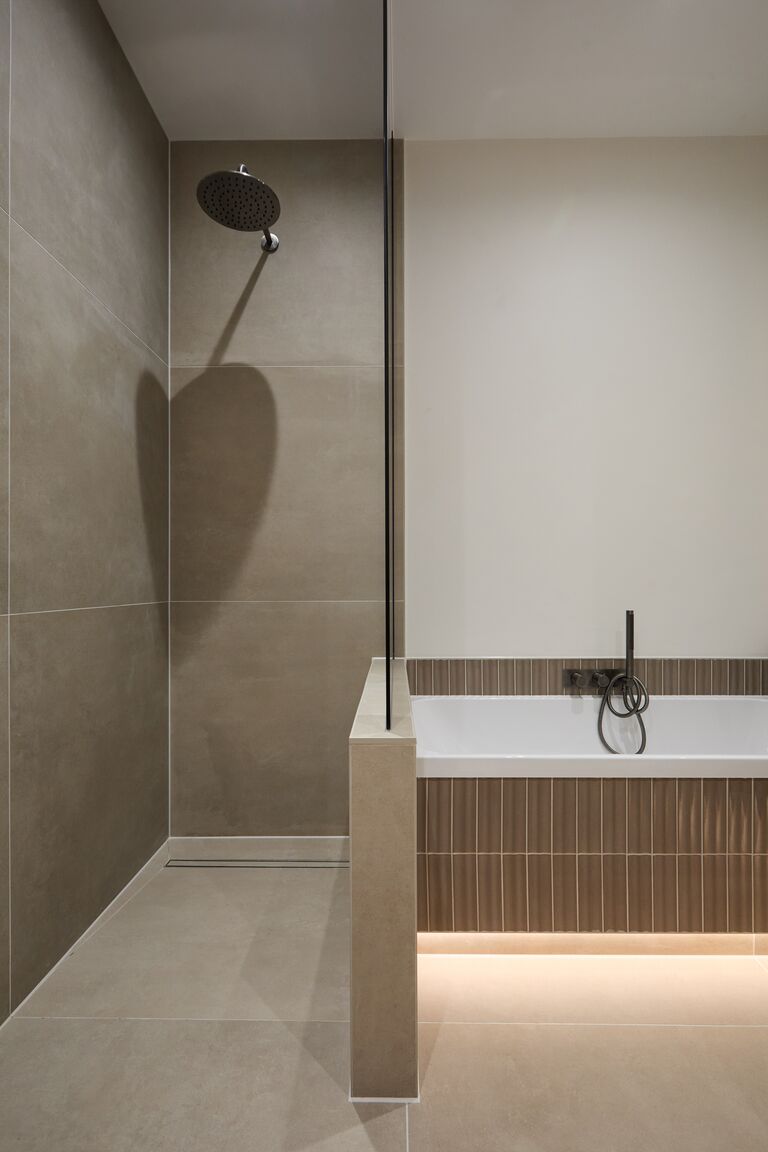 Level-access wetroom shower with linear drain beside fluted tile bath Chelmsford CM2 Essex