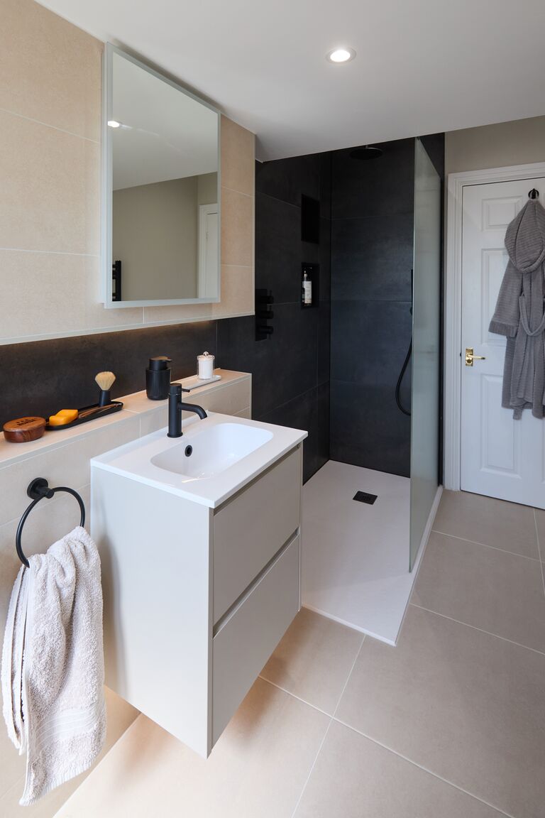 White floating vanity with matt black tap and dark slate-look shower behind Chelmsford CM2 Essex Bowman Bathrooms
