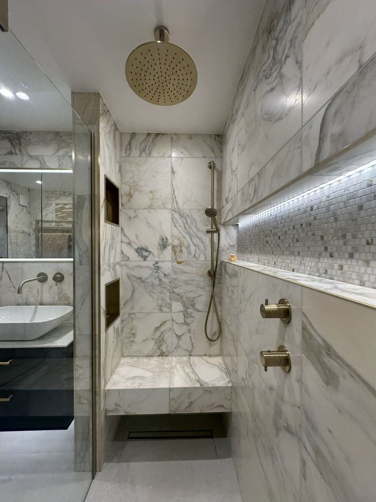 JTP brushed brass ceiling rainfall shower, marble bench and lit mosaic niche beside the Roper Rhodes vanity in the Chelmsford CM3 ensuite